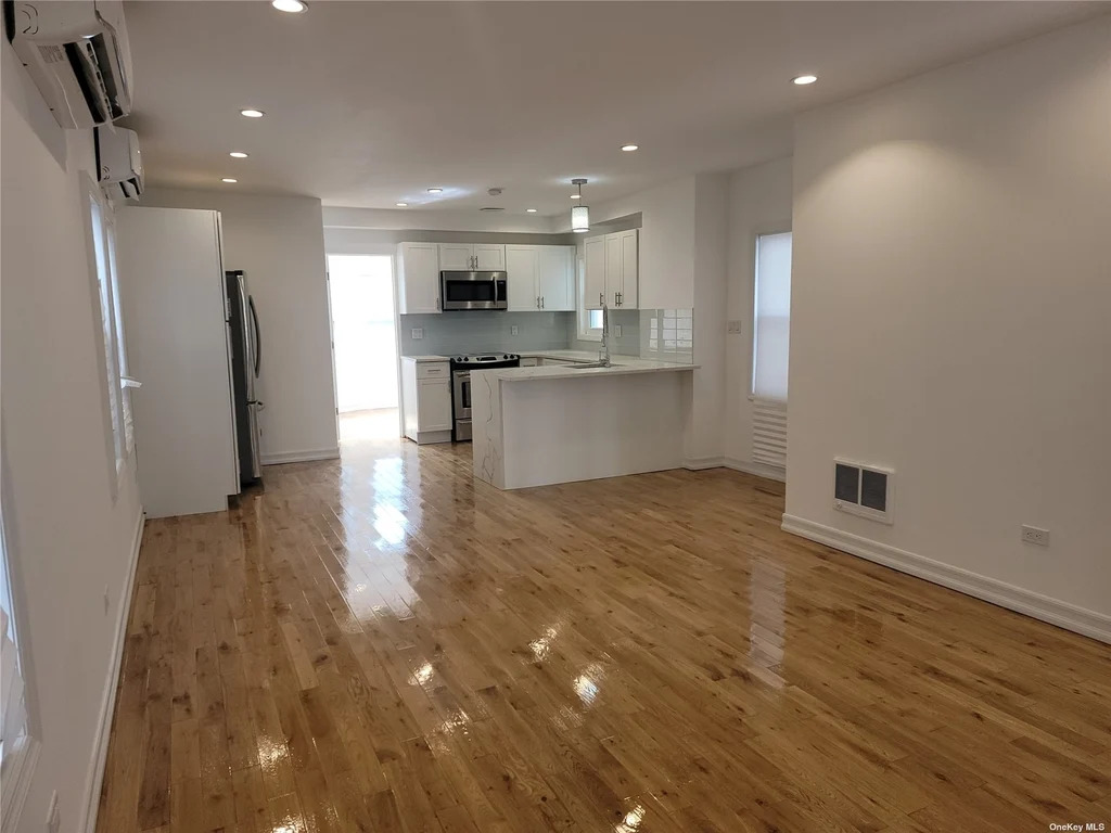 Open concept living and kitchen room in Queens with new appliances