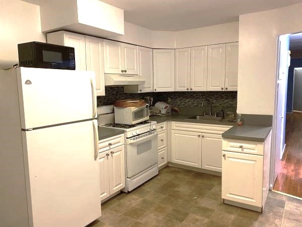 Kitchen in Queens with whtie appliances