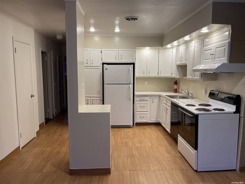 Kitchen with white appliances in Queens