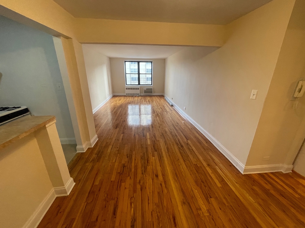Large living room in Queens with kitchen to the left