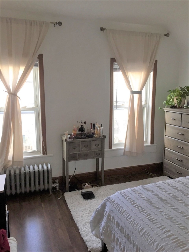 Bedroom with multiple windows in Queens