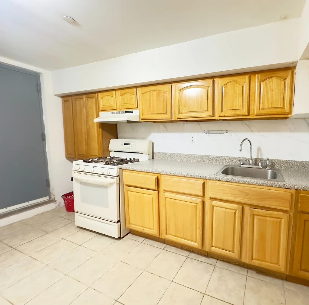 Kitchen in Queens with wood cabinets