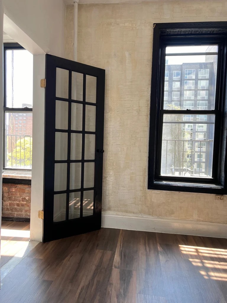 Bedroom with dark wood accents and a window