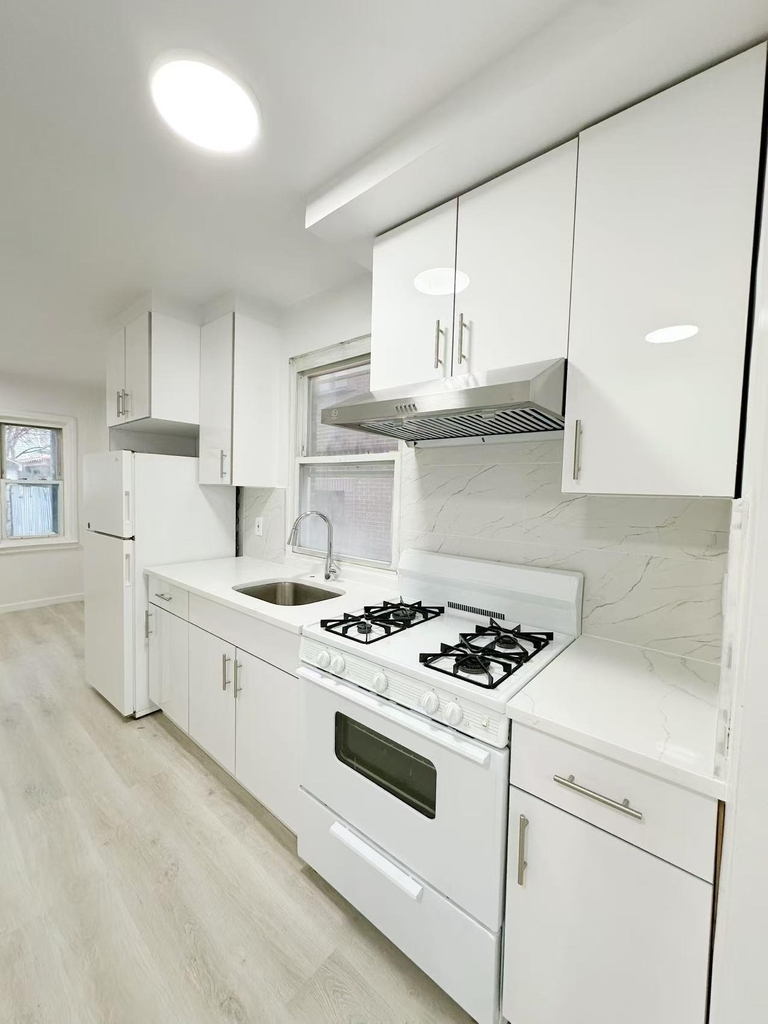 Queens kitchen with white appliances and cabinets