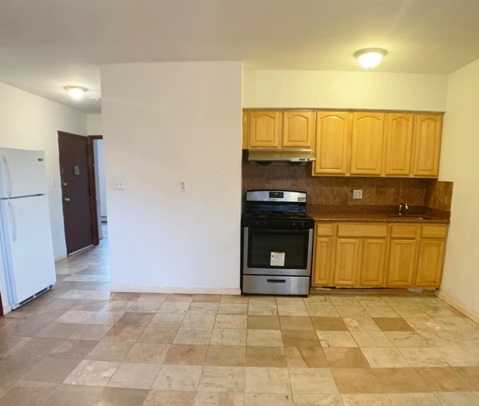 apartment listing photo of empty kitchen space with fridge