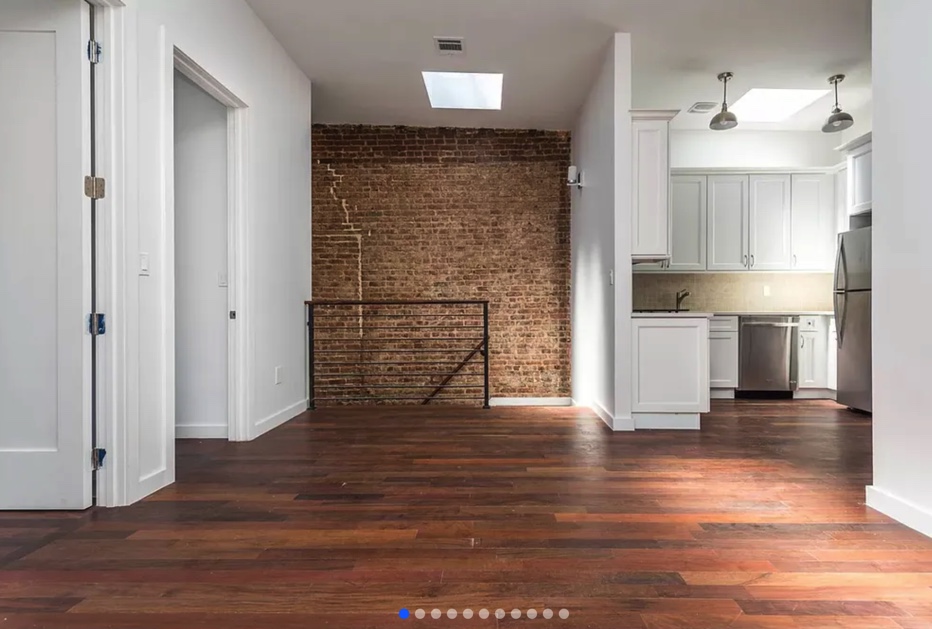 apartment listing photo of empty room and kitchen