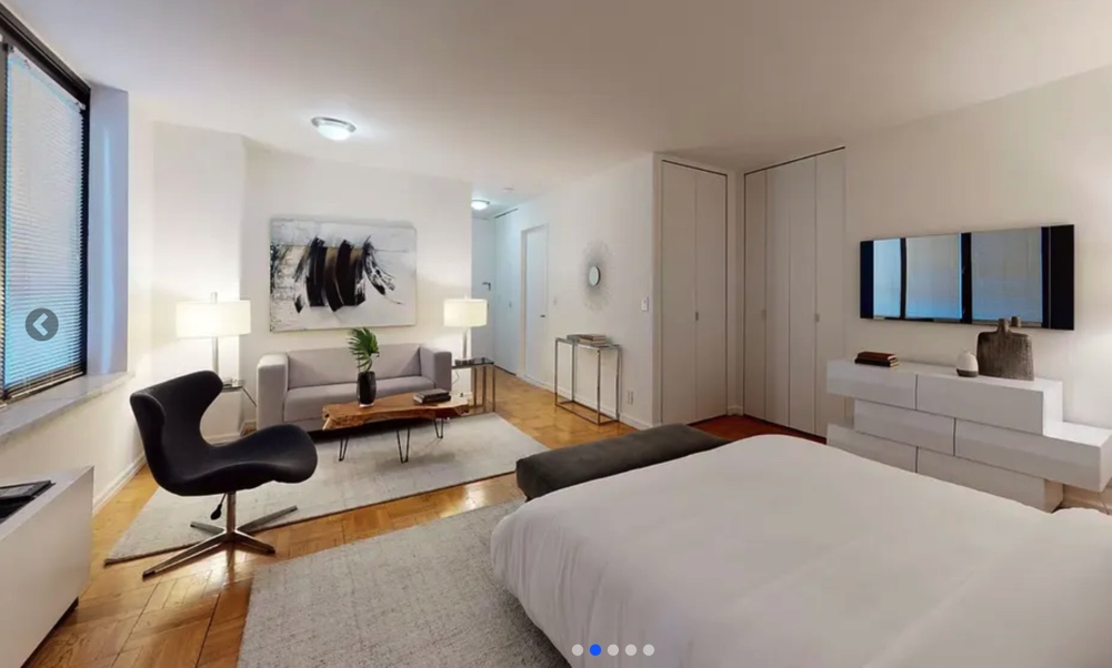 photo of studio apartment with bed and rest of the space in frame
