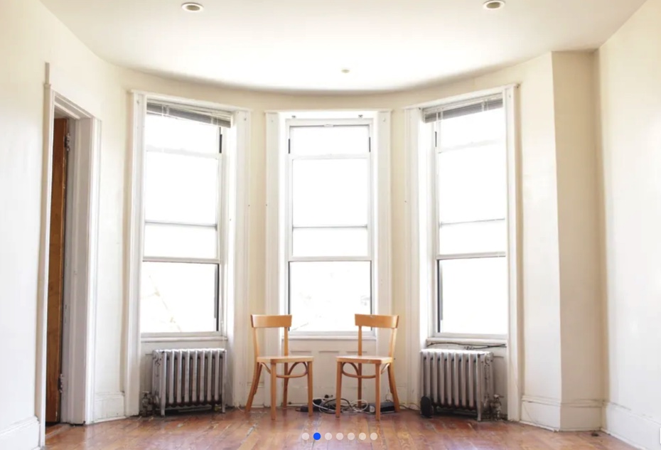 apartment photo of big windows and two chairs