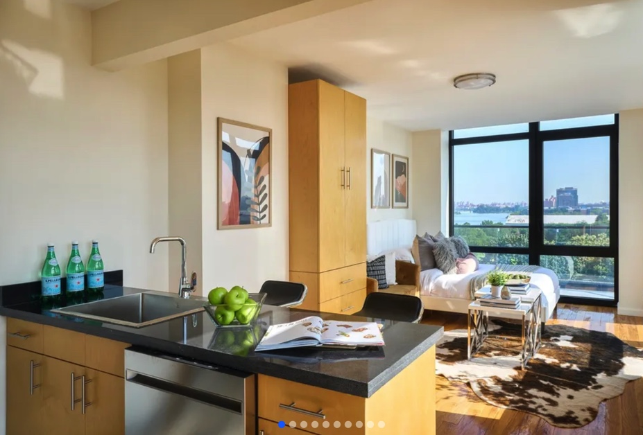apartment listing photo of furnished studio bedroom with bed, kitchen table, and view of outdoors