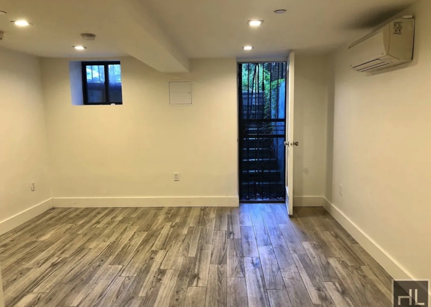 apartment listing photo of empty room and entrance into the backyard