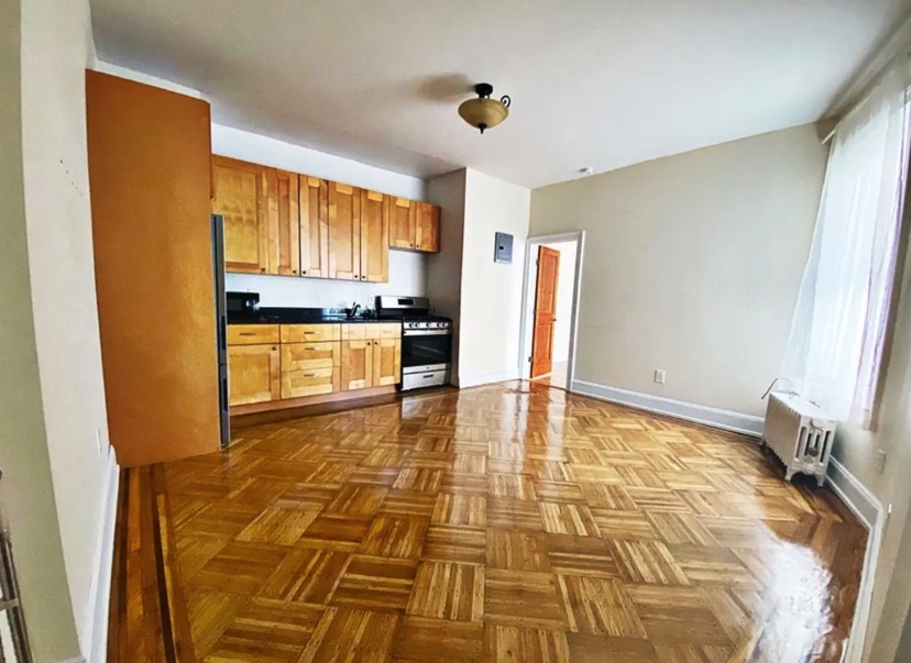 apartment photo of empty room and kitchen