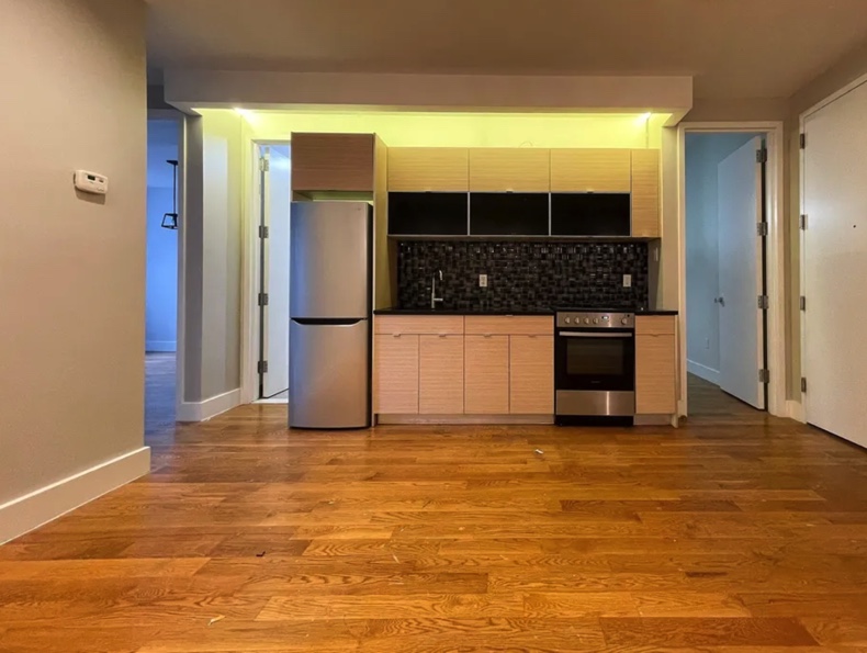 apartment listing photo of kitchen and empty living room