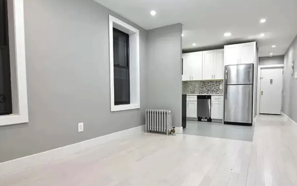 apartment listing photo empty living room, kitchen, and foyer with front entrance