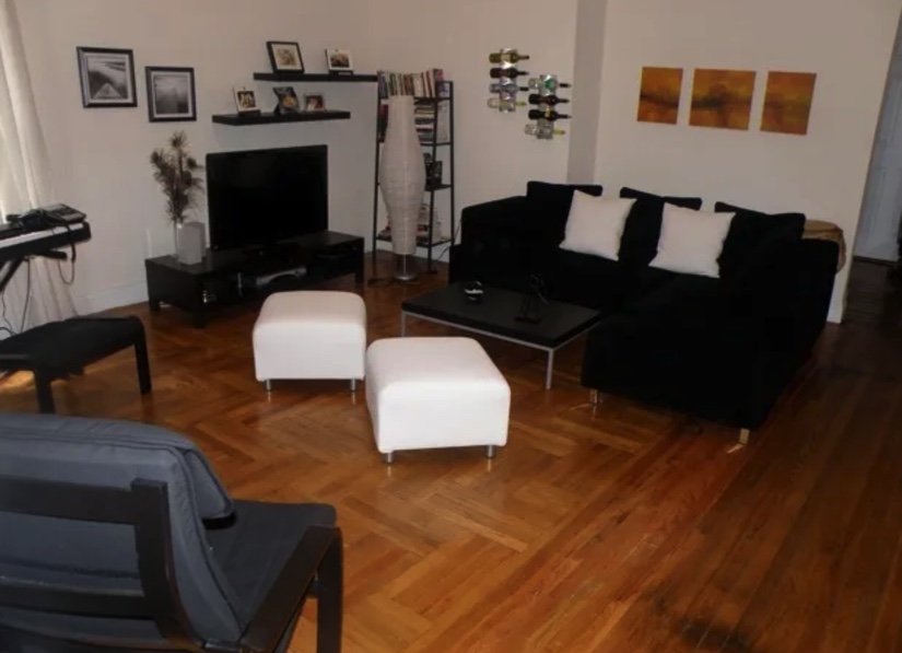 apartment listing photo of living room sofa, coffee table, and tv with decorations