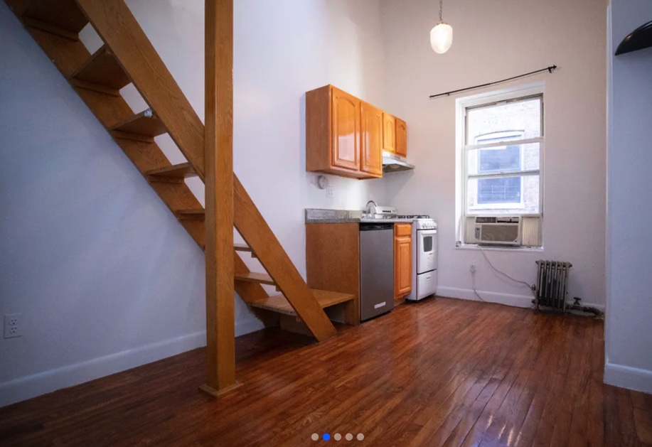 apartment photo empty living room with staircase and a kitchen