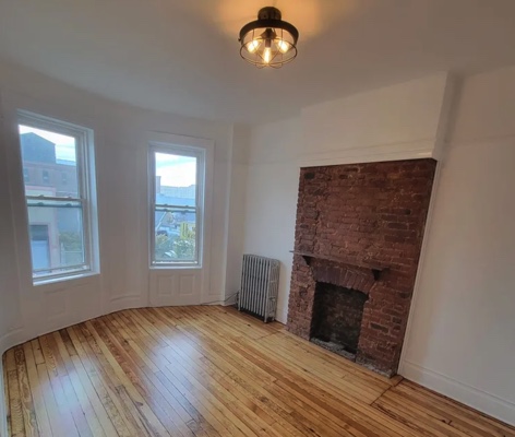 apartment listing photo of empty room with fireplace