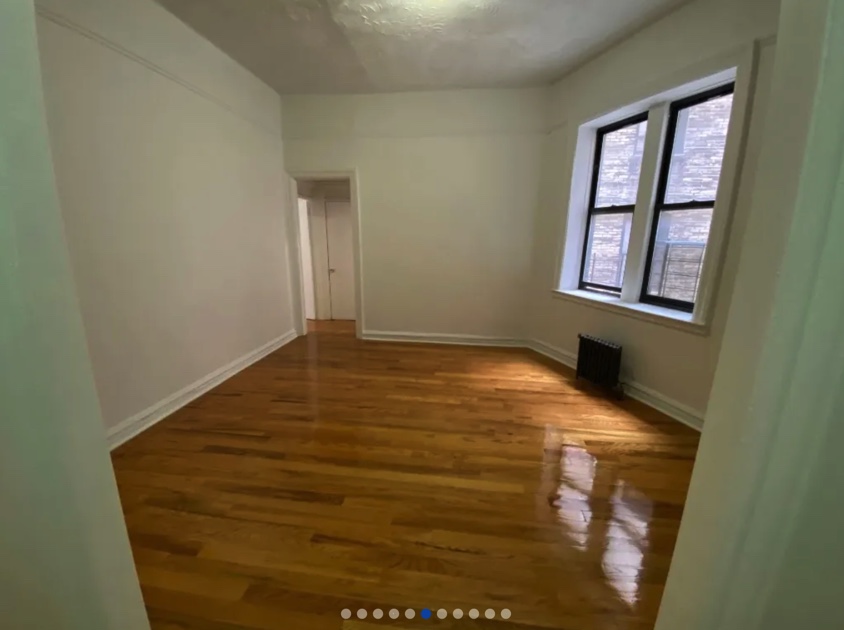 apartment photo of empty room with windows and radiator