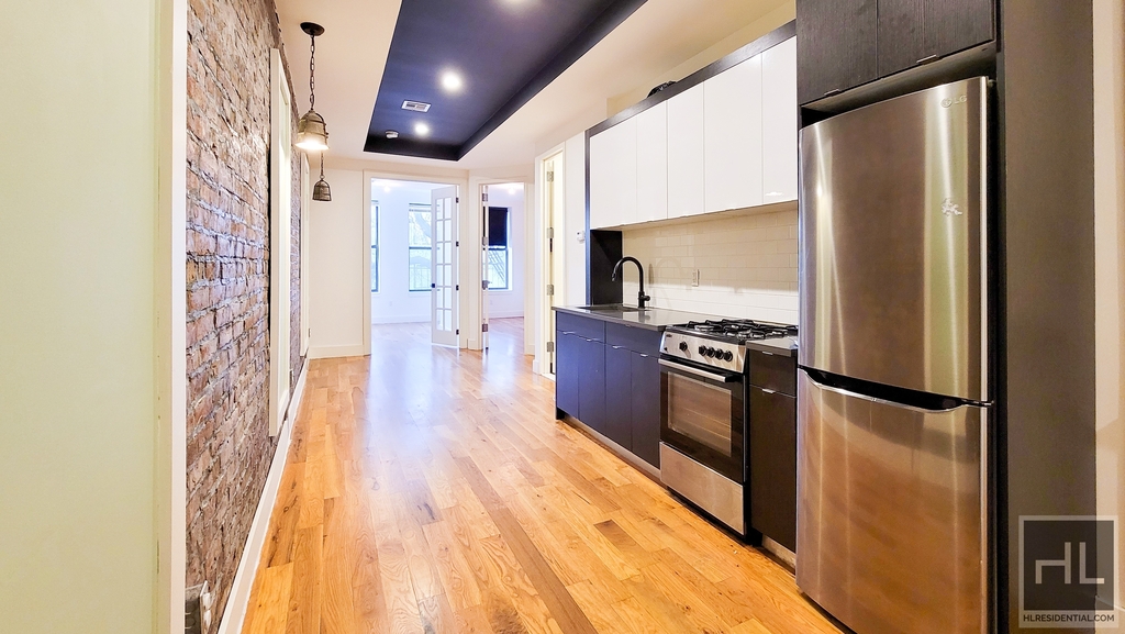 apartment listing photo of empty room and kitchen