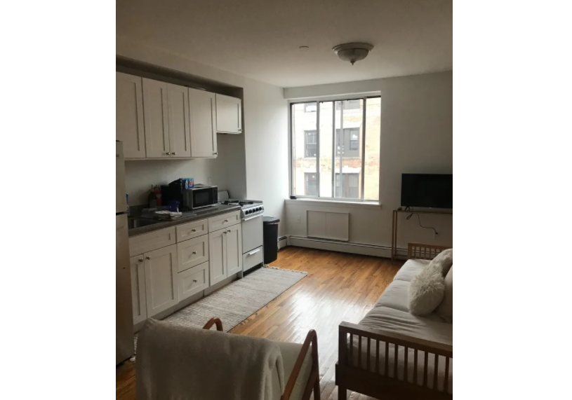 photo of living room with open kitchen the background
