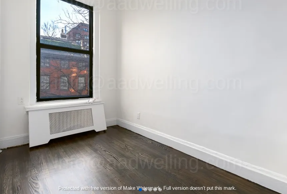 apartment photo of empty room with window and heater