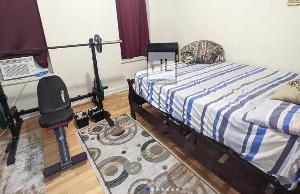 apartment listing photo of bedroom with bed and weight lifting rack