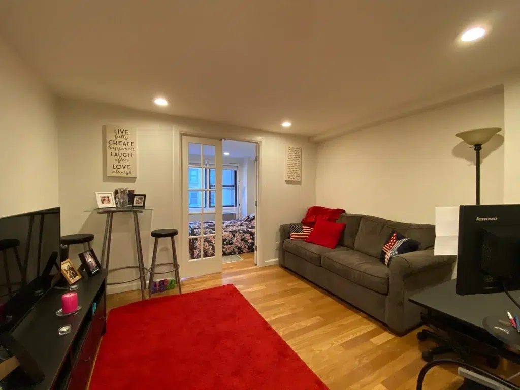 photo of furnished living room with bedroom in the background and french doors
