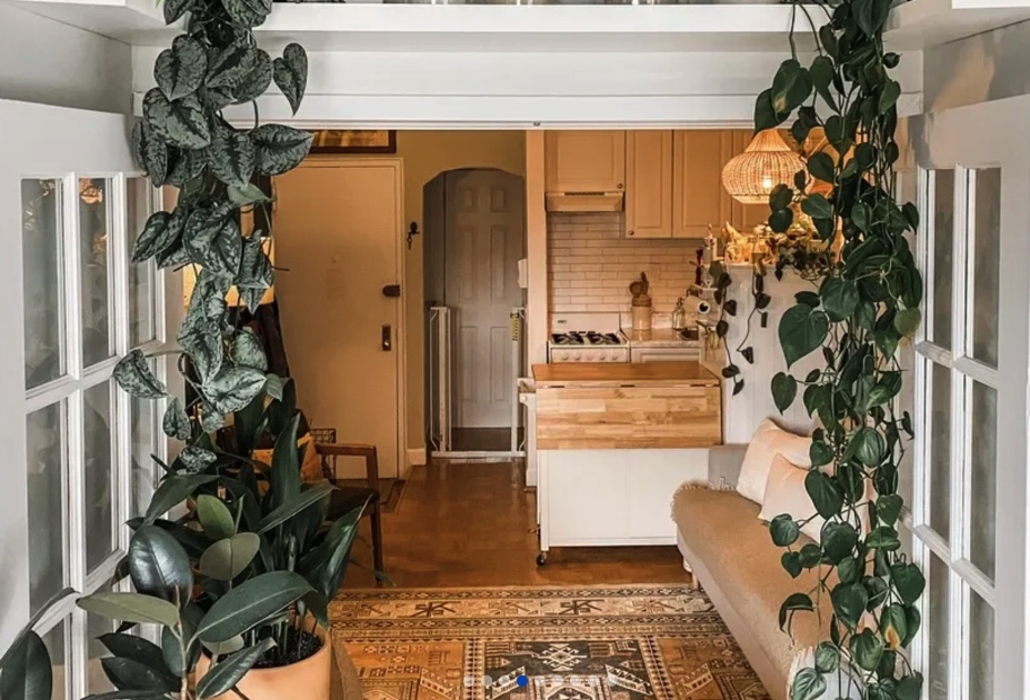 photo of furnished living room with kitchen in the background and french doors