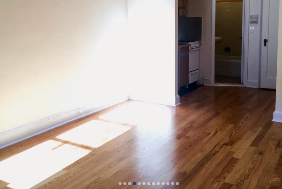 apartment of empty room with kitchen in background