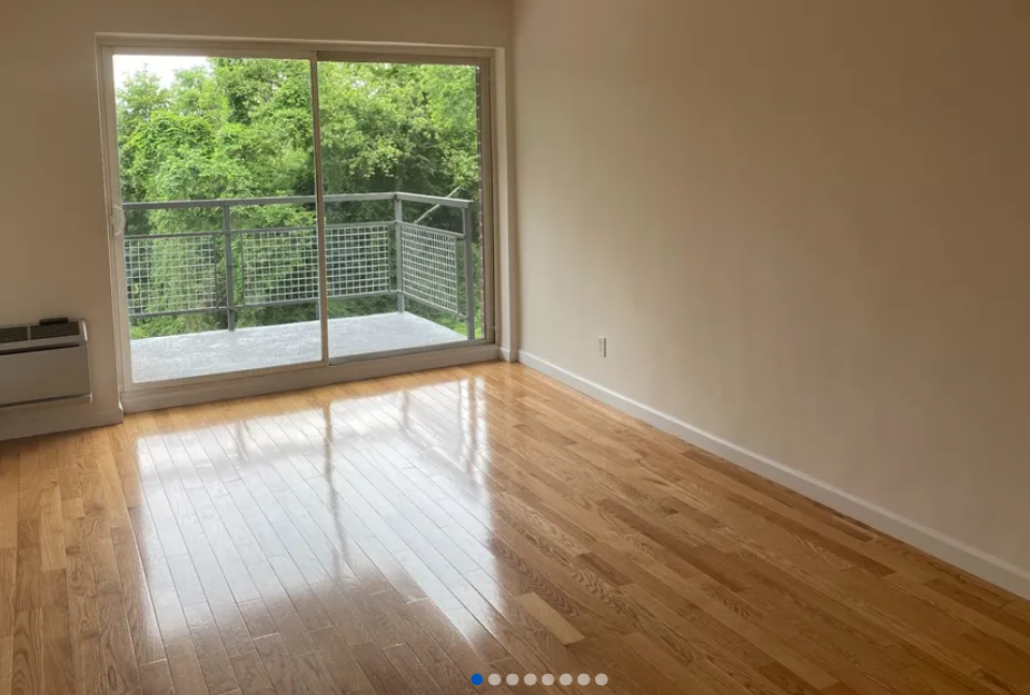 apartment listing photo of empty room with a sliding door to private balcony