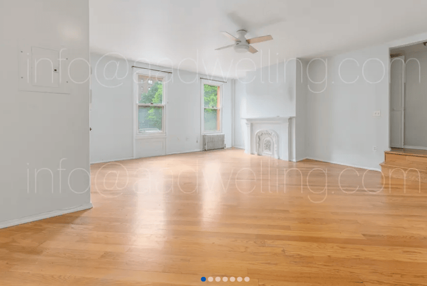 empty apartment living room with fireplace and windows