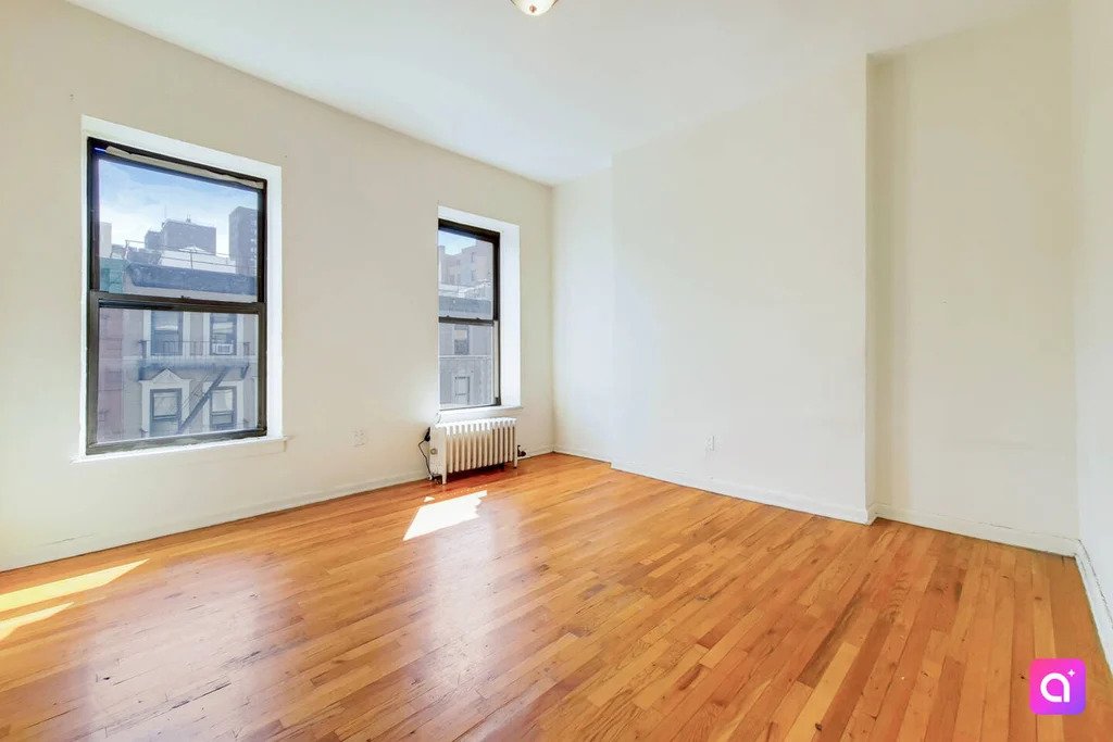 large room with two windows and sunlight