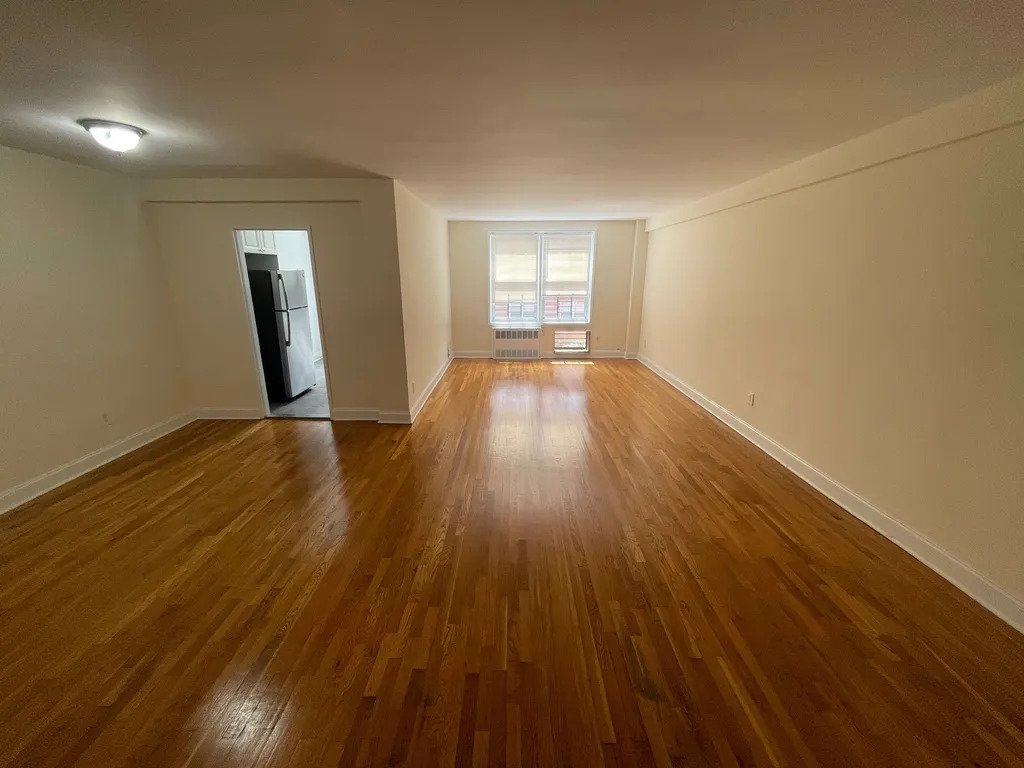 apartment listing photo of an empty room with ceiling fan and window
