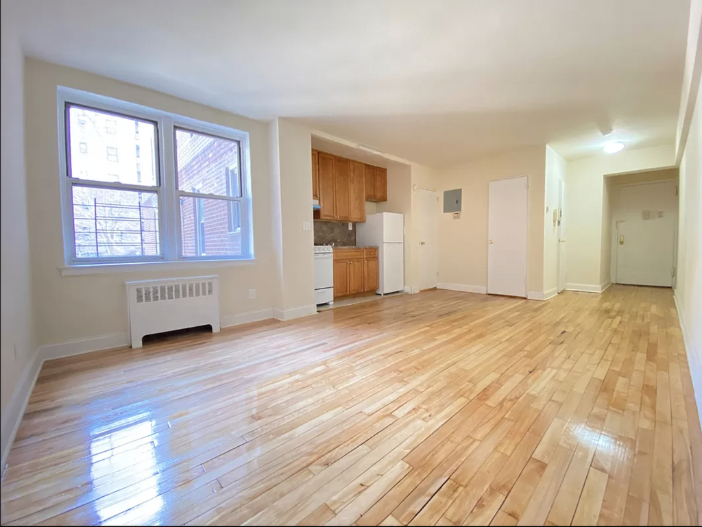 apartment listing photo of an empty studio with a kitchen