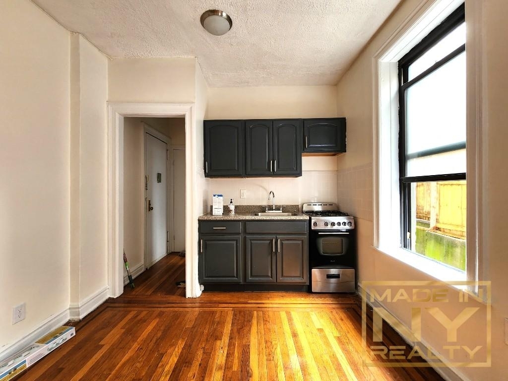 bright kitchen with dark cabinetry and a stainless steel stove