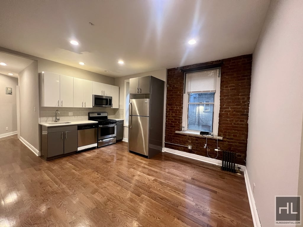 living room with exposed brick and open kitchen
